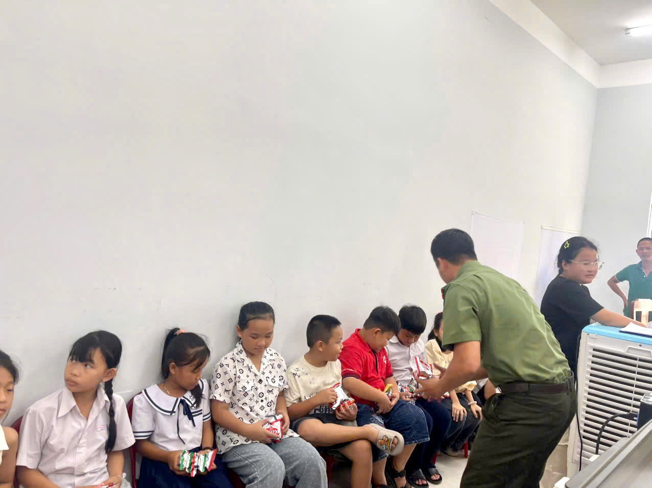 BCH chi đoàn Công an xã tặng bánh và nước cho các em trong thời gian chờ làm thủ tục cấp căn cước