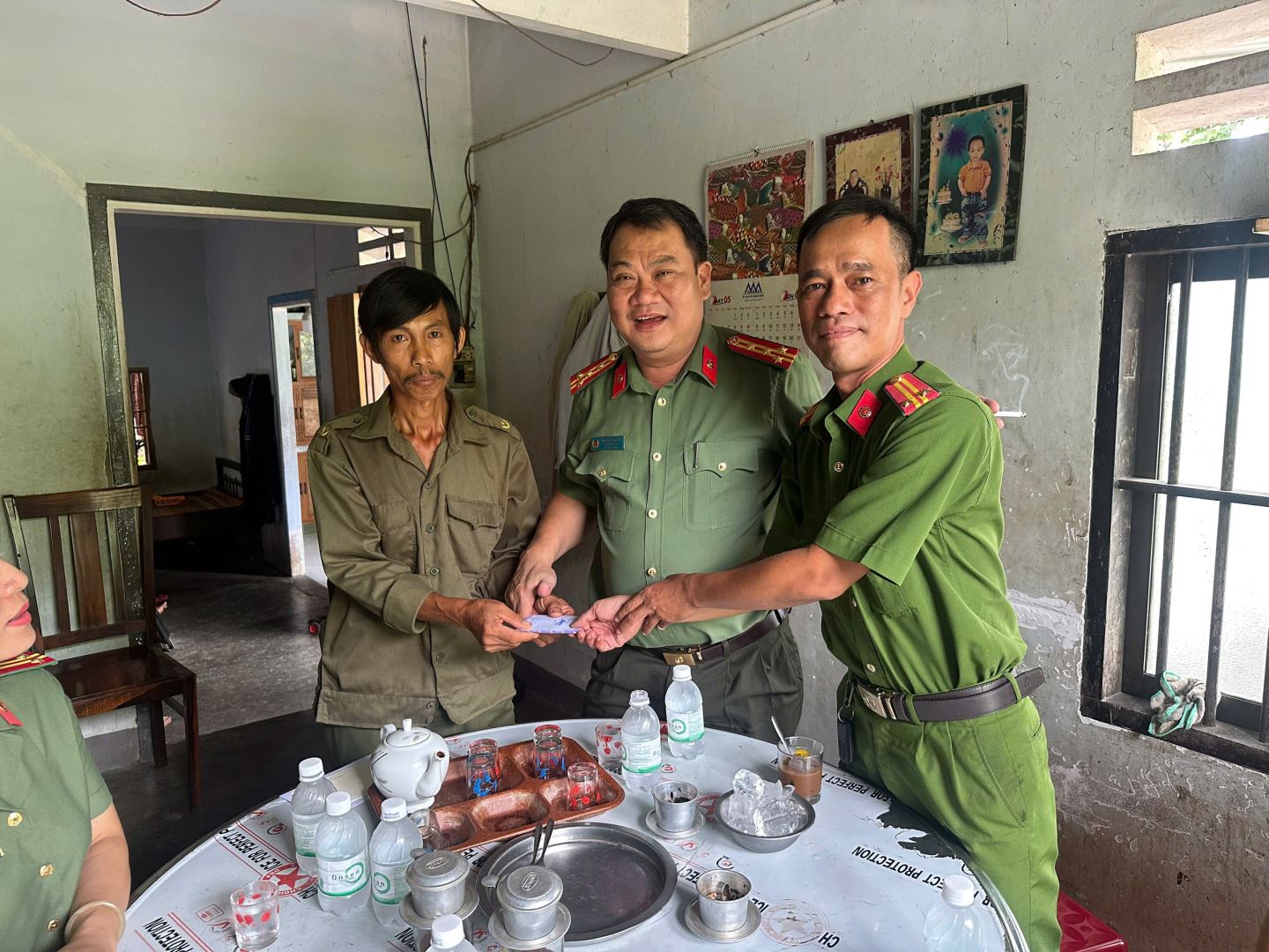 Đồng chí Trung tá Phạm Từ Thông, Trưởng Công an xã đại diện Công an xã Hòa Trí tặng quà cho anh Chương