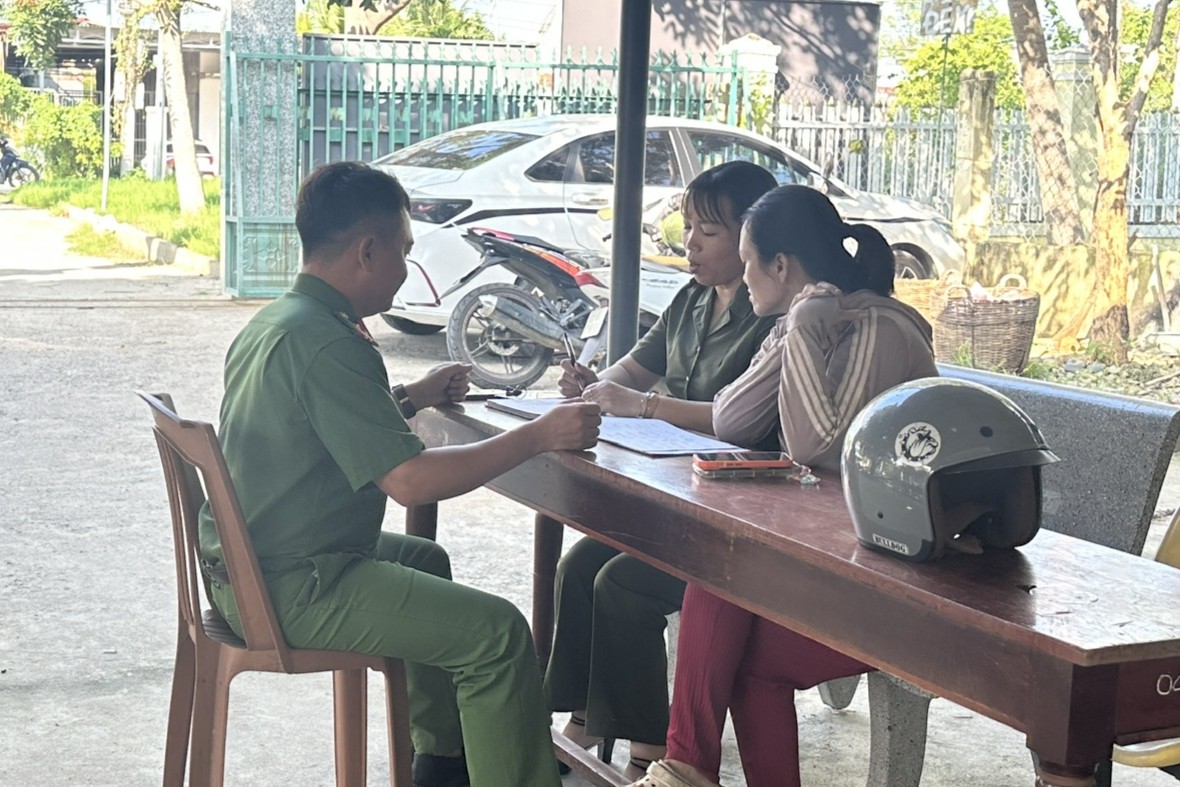 Nữ thành viên lực lượng tham gia bảo vệ ANTT ở cơ sở phối hợp cùng Công an xã Mỹ Sơn hướng dẫn, hỗ trợ người dân giải quyết công việc.