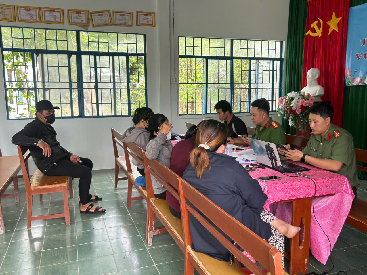 Đại úy Hồ Xuân Đức hướng dẫn người dân sử dụng dịch vụ công trực tuyến tại Nhà cộng đồng thôn Nha Húi, xã Mỹ Sơn.