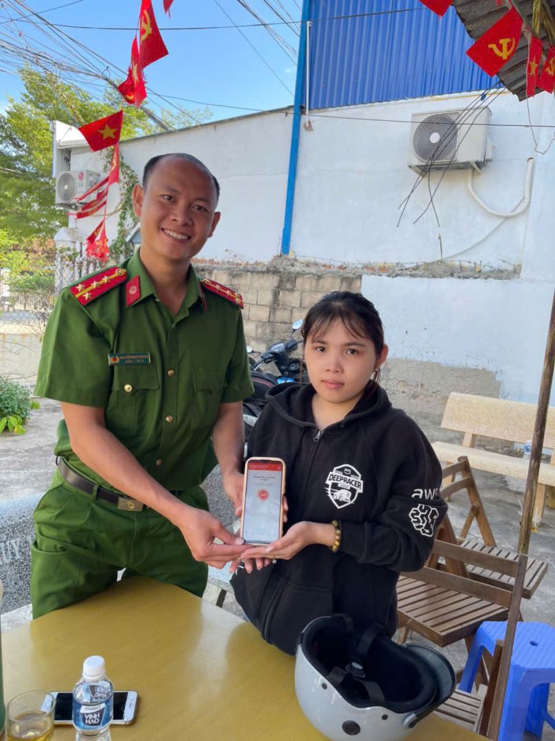Ảnh: CBCS Công an xã tuyên truyền và hướng dẫn người dân cài đắt ứng dụng "Báo cháy 114"