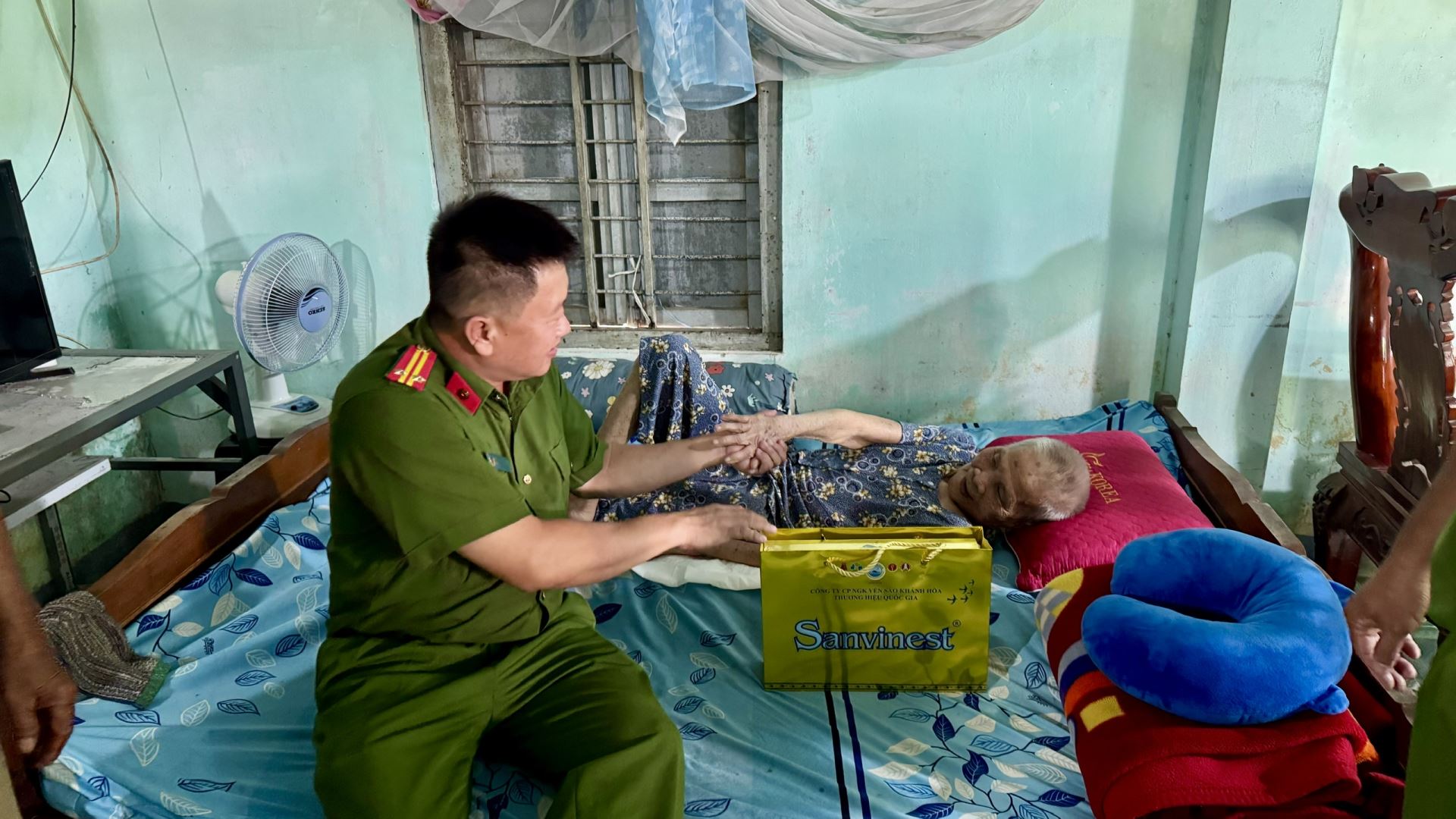 Đồng chí Trung tá Nguyễn Quốc Việt ân cần thăm hỏi, động viên thân nhân liệt sĩ trong buổi đến thăm và tặng quà.