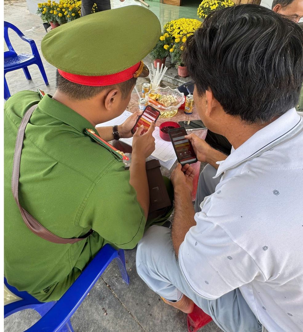 Cán bộ đang hướng dẫn thao tác trên ứng dụng VNeID cho người dân