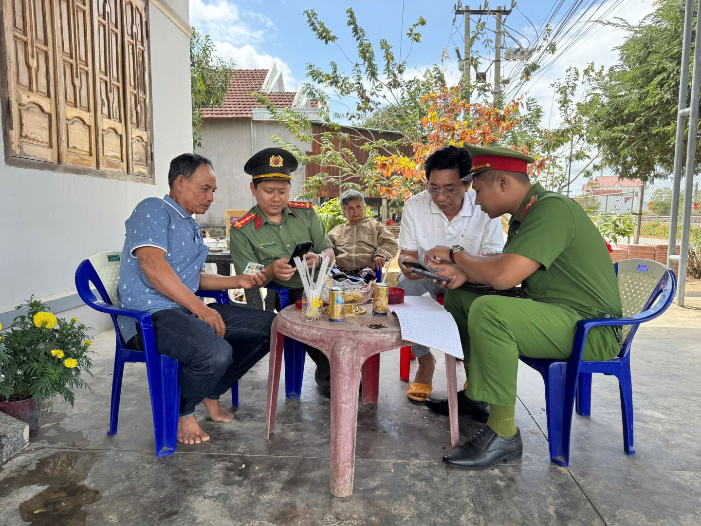 Công an xã cùng Tổ chuyển đổi số cơ sở hướng dẫn người dân