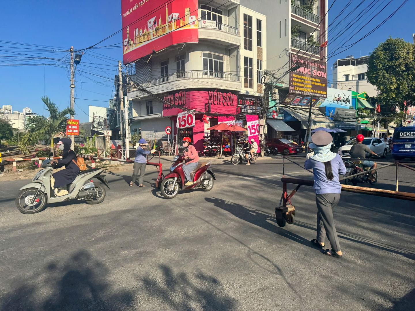 nhân viên gác chắn tàu kéo barie đảm bảo an toàn giao thông đường sắt