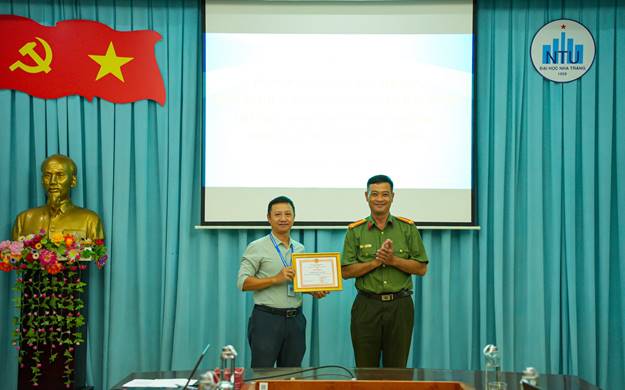 Đồng chí Thượng tá Lê Kim Vương, Phó Trưởng phòng trao Giấy khen của Giám đốc Công an tỉnh cho tập thể Trường Đại học Nha Trang.